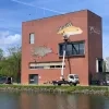 De beeltenis van een rietvoorn en een pos sieren de gevel van het gebouw van De Vlaamse Waterweg