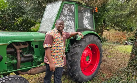 Pastor Joseph bij zijn tractor voor Congo